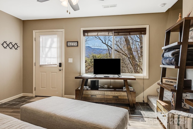 bedroom with wood finished floors, multiple windows, baseboards, and visible vents