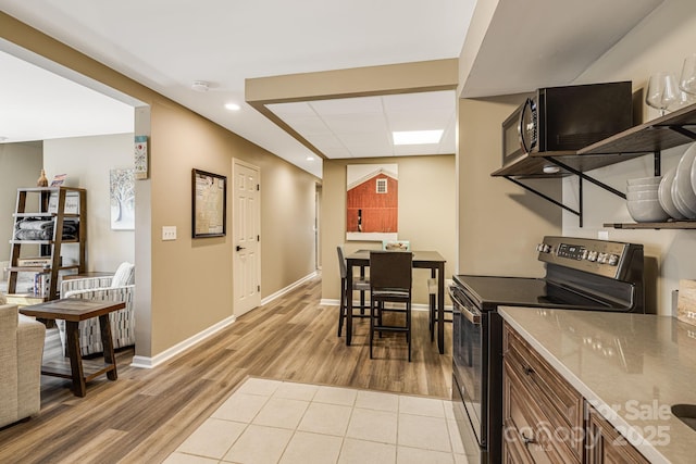 kitchen with recessed lighting, stainless steel range with electric cooktop, light wood-type flooring, and baseboards