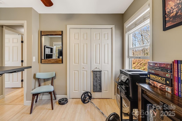 home office featuring a ceiling fan, light wood-style floors, and baseboards