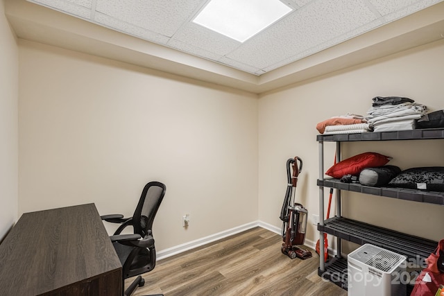 office featuring wood finished floors, baseboards, and a drop ceiling