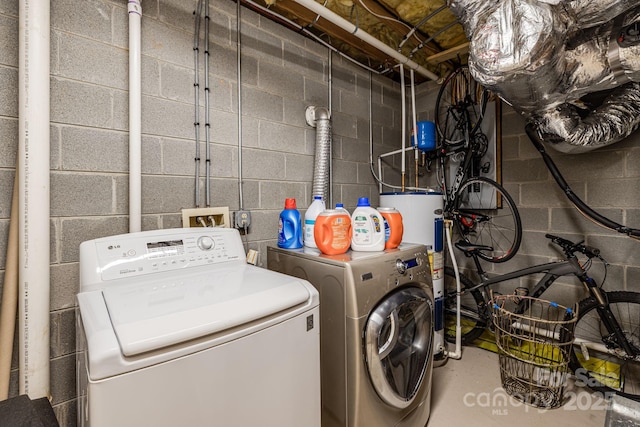 laundry room featuring water heater, laundry area, and separate washer and dryer