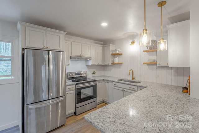 kitchen featuring open shelves, light stone counters, under cabinet range hood, a sink, and stainless steel appliances