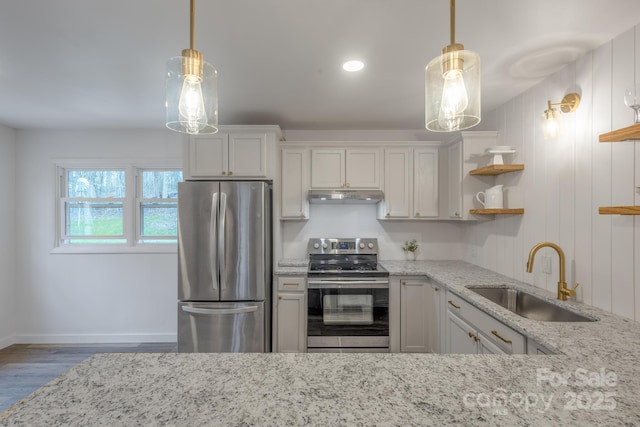 kitchen with a sink, light stone countertops, under cabinet range hood, appliances with stainless steel finishes, and open shelves