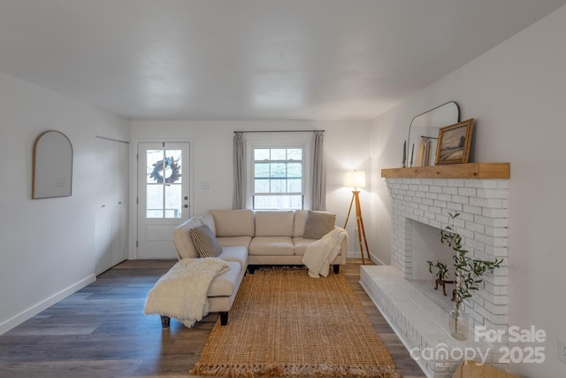 living area with a fireplace, wood finished floors, and baseboards