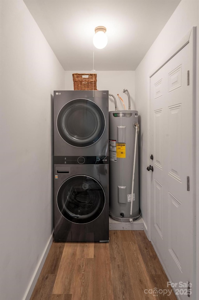 laundry area with electric water heater, wood finished floors, laundry area, and stacked washer / dryer