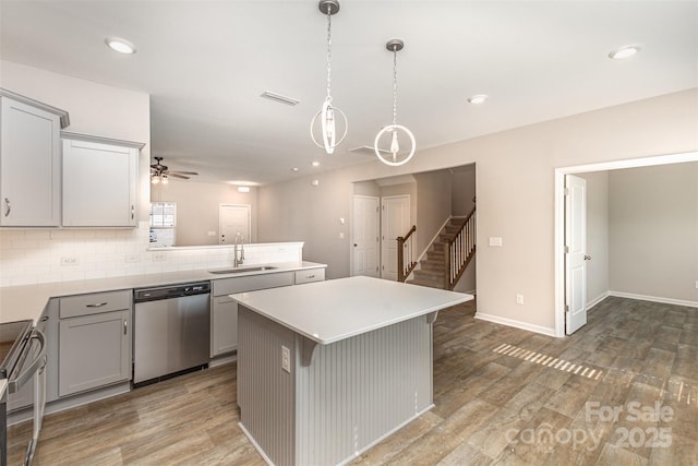 1120 Freeman View Dr, Albemarle, NC 28001 - kitchen with appliances with stainless steel finishes, a sink, gray cabinetry, a ceiling fan, and wood finished floors