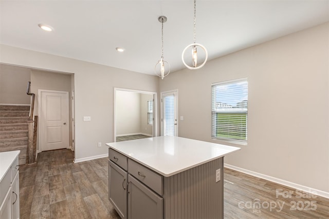1120 Freeman View Dr, Albemarle, NC 28001 - kitchen with gray cabinetry, light countertops, light wood-style flooring, a center island, and pendant lighting