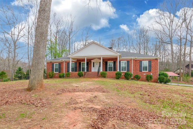 neoclassical / greek revival house featuring a front lawn, covered porch, and brick siding