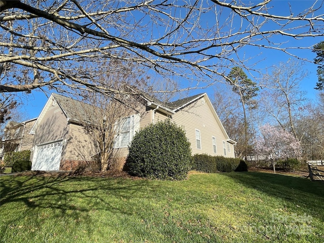 view of property exterior featuring a yard, brick siding, and an attached garage