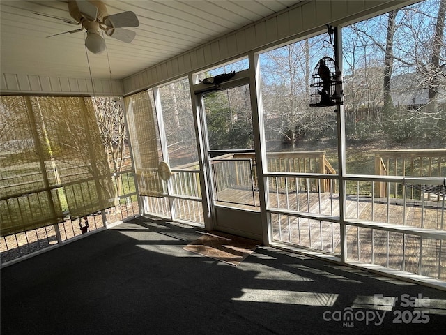 unfurnished sunroom featuring ceiling fan