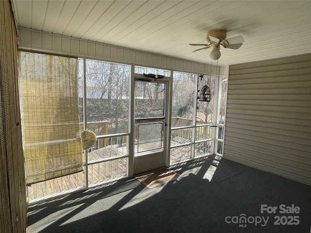 unfurnished sunroom featuring a ceiling fan