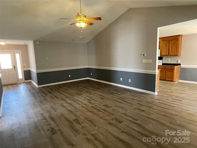 unfurnished living room featuring visible vents, ceiling fan, baseboards, vaulted ceiling, and dark wood-style floors