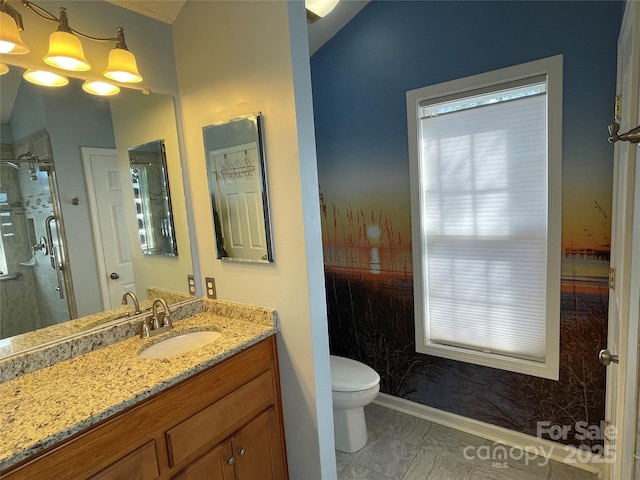 bathroom featuring vanity, toilet, baseboards, and a stall shower