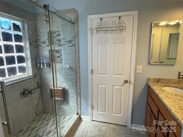 full bathroom with baseboards, vanity, and a shower stall