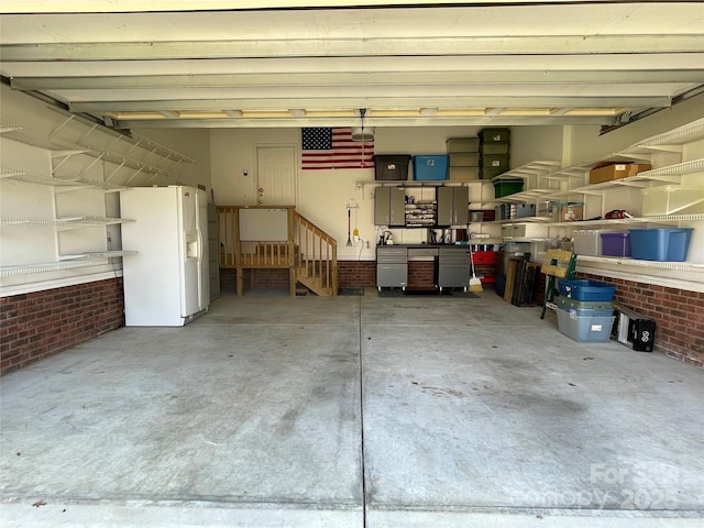 garage featuring white refrigerator with ice dispenser