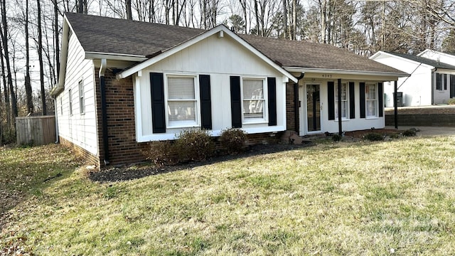 single story home with brick siding, a shingled roof, and a front lawn