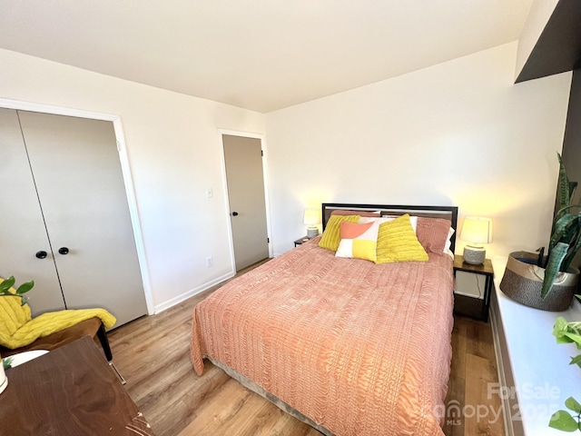 bedroom featuring a closet, baseboards, and wood finished floors