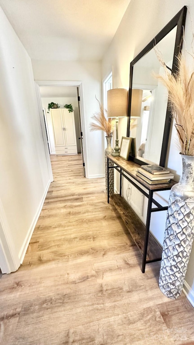 hallway with baseboards and light wood-type flooring