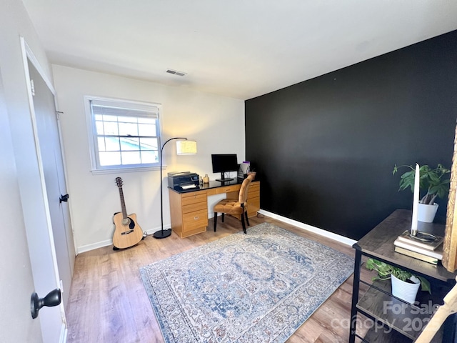 office area with visible vents, baseboards, and light wood finished floors