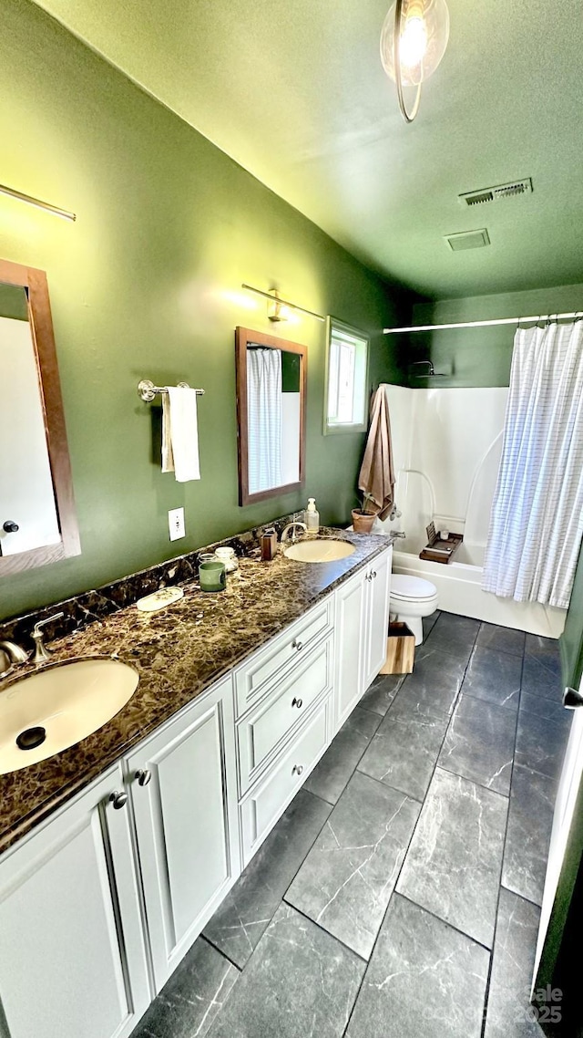 full bathroom with double vanity, toilet, shower / tub combo, and a sink