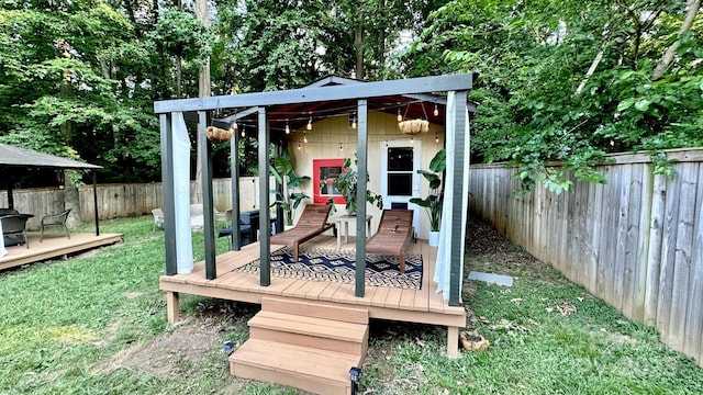 wooden deck featuring a yard, an outbuilding, and a fenced backyard