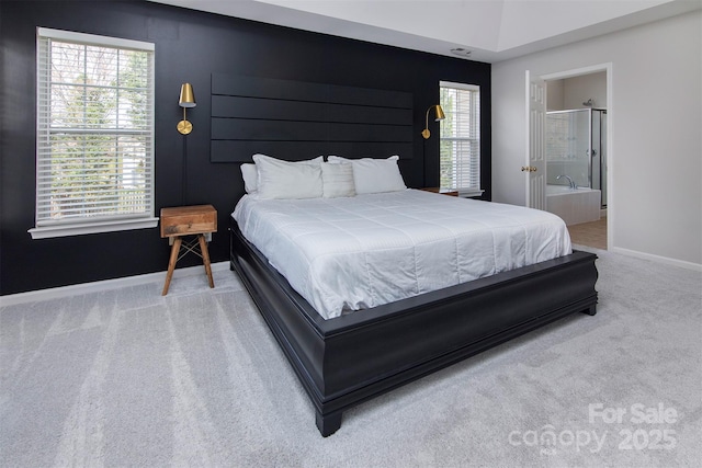 bedroom featuring baseboards, ensuite bathroom, and carpet