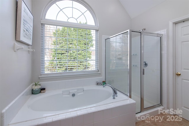 full bathroom with a shower stall, a bath, a wealth of natural light, and vaulted ceiling