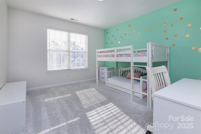 bedroom featuring visible vents, baseboards, wallpapered walls, an accent wall, and carpet flooring