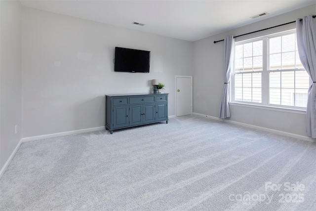 unfurnished bedroom featuring baseboards, visible vents, and light carpet