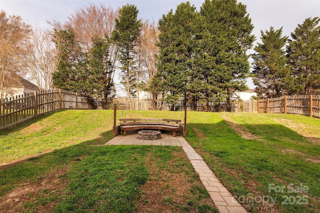 view of yard featuring a patio, a fenced backyard, and an outdoor fire pit