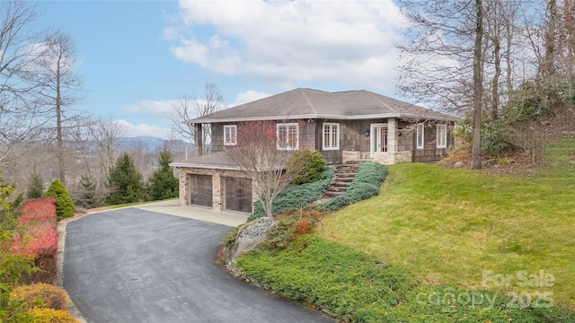 view of front facade featuring driveway, an attached garage, and a front lawn