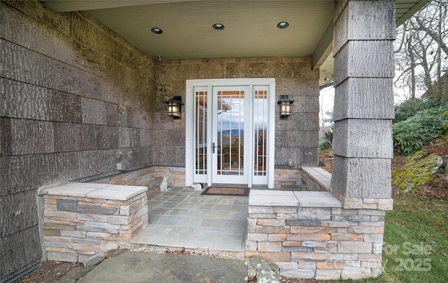 view of exterior entry with a patio