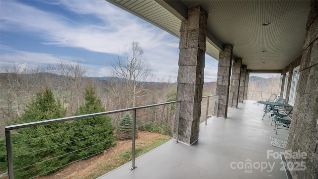 balcony featuring a forest view