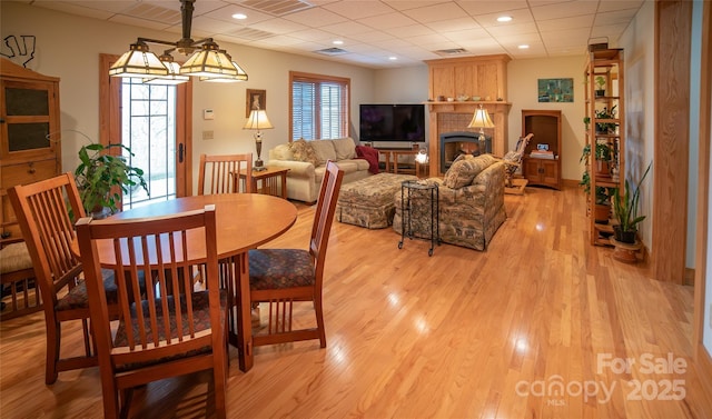 dining room featuring visible vents, recessed lighting, a fireplace, a paneled ceiling, and light wood-type flooring