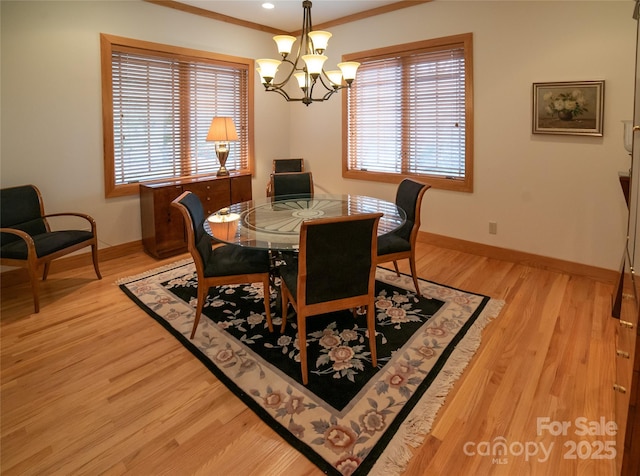 dining area with a wealth of natural light, baseboards, light wood-style floors, and an inviting chandelier