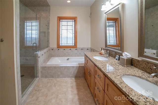 bathroom with a healthy amount of sunlight, a stall shower, and a sink