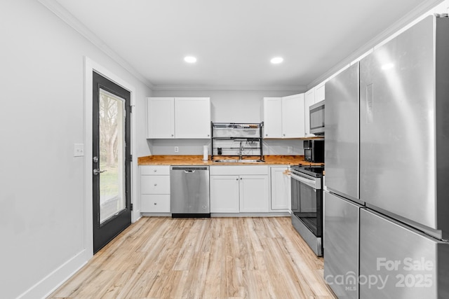 2318 Knight Dr, Gastonia, NC 28052 - kitchen with white cabinetry, ornamental molding, a sink, and stainless steel appliances