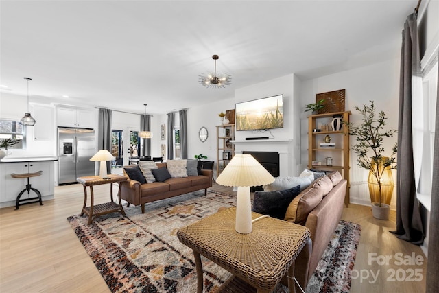 living room with light wood-style flooring and a fireplace