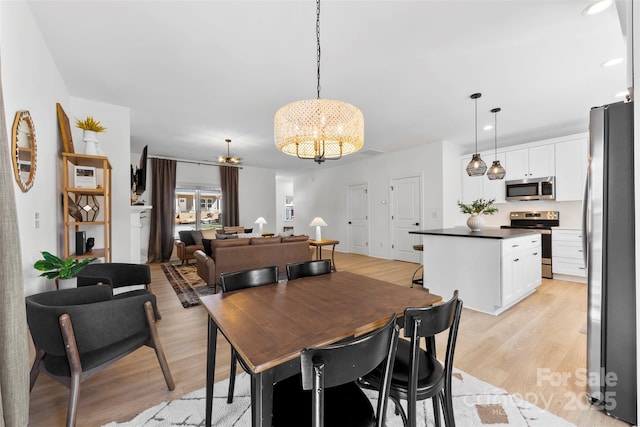 dining area with recessed lighting, light wood-style floors, and a chandelier