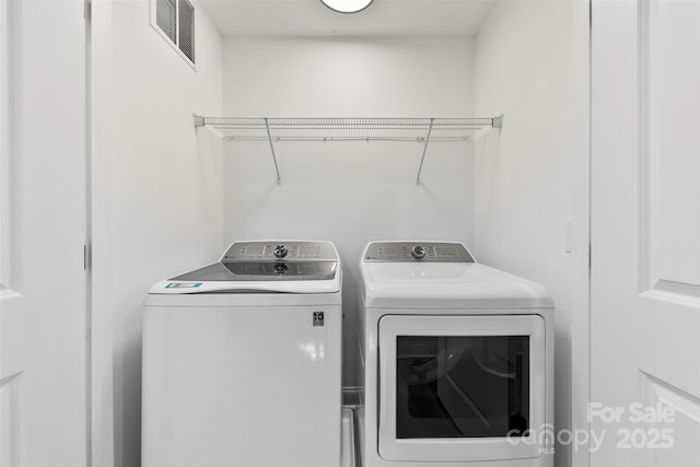 laundry room with laundry area, visible vents, and washing machine and clothes dryer