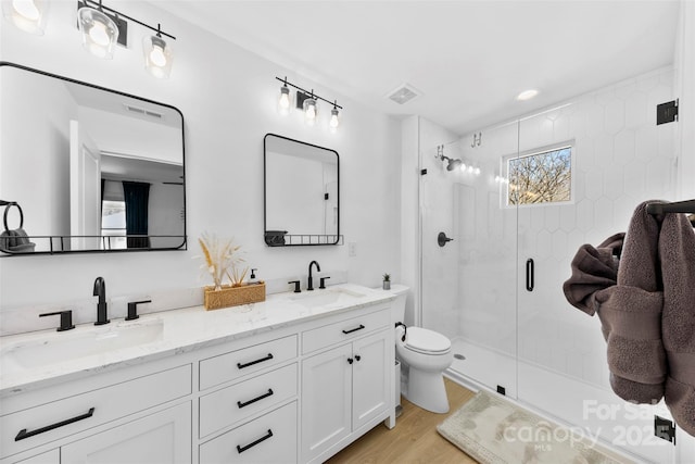 4114 Rutgers Ave, Charlotte, NC 28206 - full bathroom with double vanity, toilet, a stall shower, and wood finished floors
