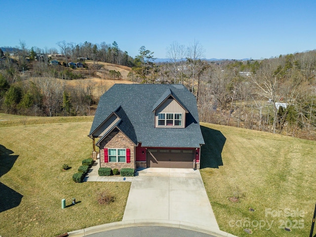 view of front of house featuring driveway, a front lawn, stone siding, roof with shingles, and a garage