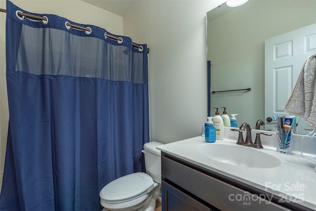 full bathroom featuring curtained shower, toilet, and vanity