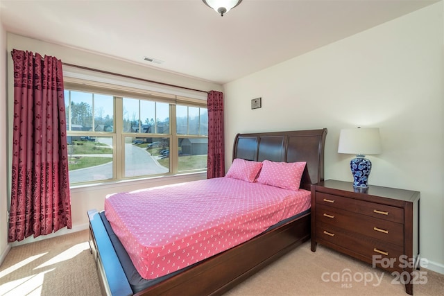 bedroom featuring visible vents, multiple windows, and light colored carpet