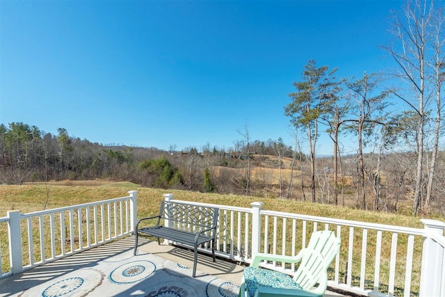 wooden terrace featuring a wooded view