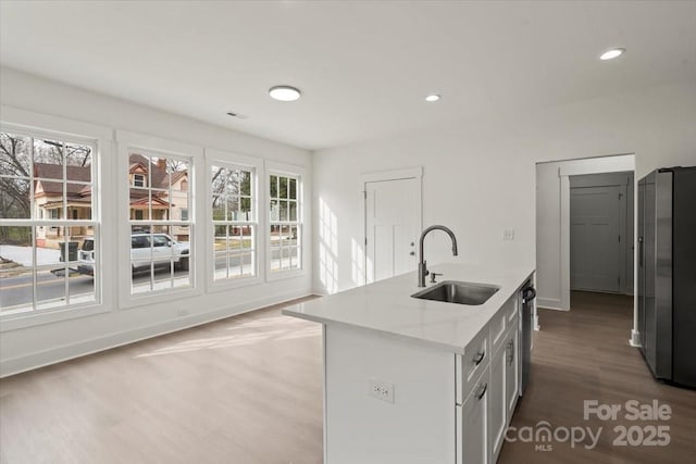 kitchen with recessed lighting, stainless steel appliances, a sink, light wood-style floors, and white cabinetry