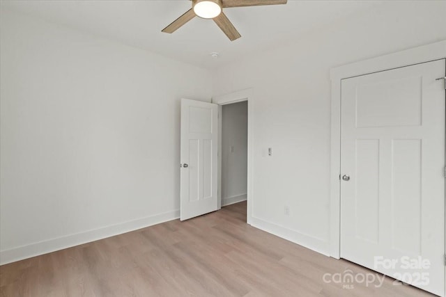 unfurnished bedroom featuring baseboards, ceiling fan, and light wood finished floors