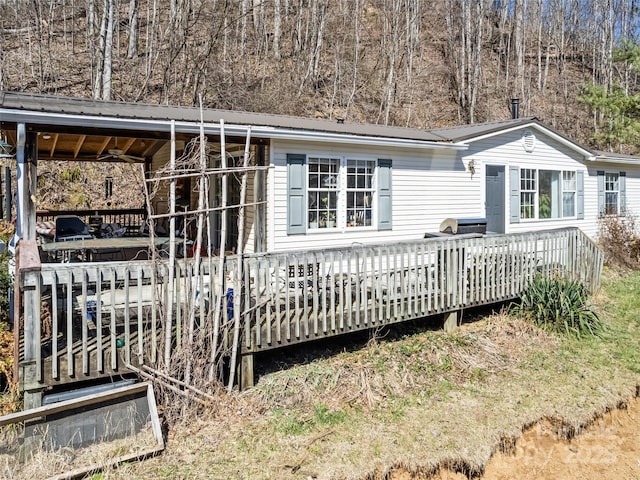 exterior space featuring metal roof, an attached carport, and a wooden deck