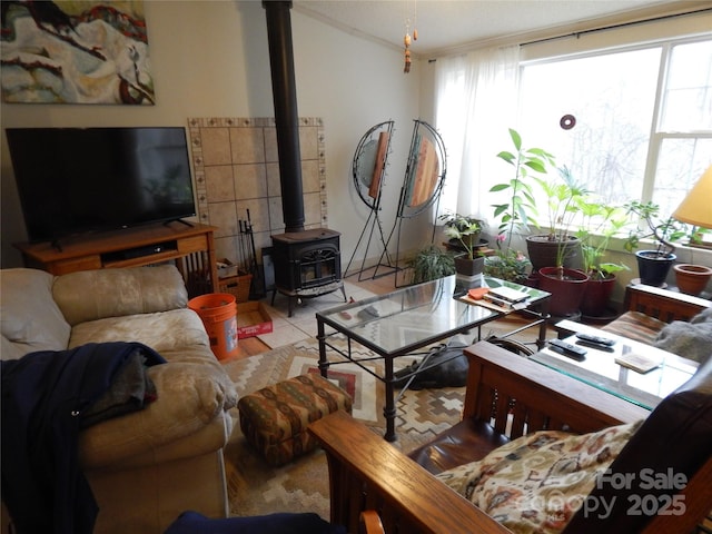 tiled living room featuring a healthy amount of sunlight, a wood stove, and vaulted ceiling