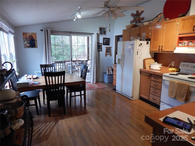 kitchen featuring white appliances, a ceiling fan, dark wood-style floors, vaulted ceiling, and under cabinet range hood